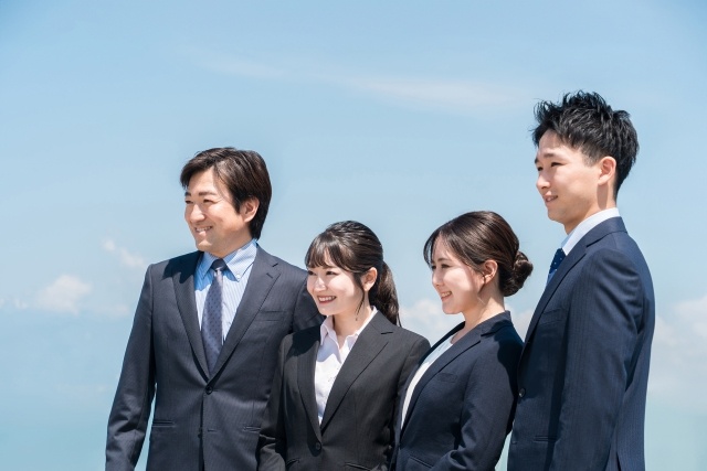 青空とスーツを着た男女