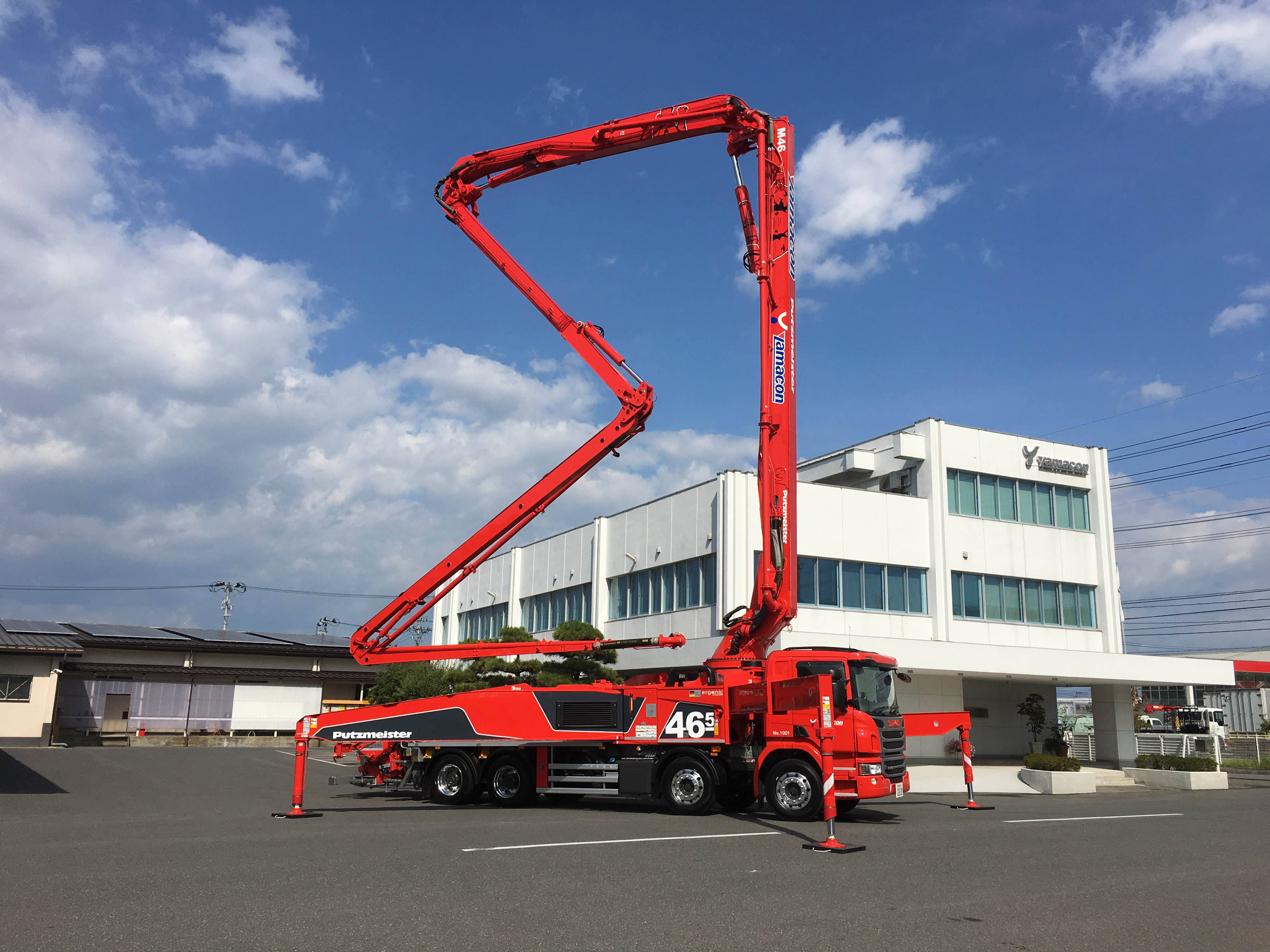 社屋の前にあるコンクリートポンプ車の写真