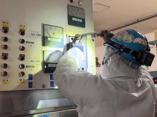 配電盤のチェックを行う作業員