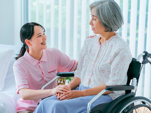 車椅子の女性を介助する女性の写真