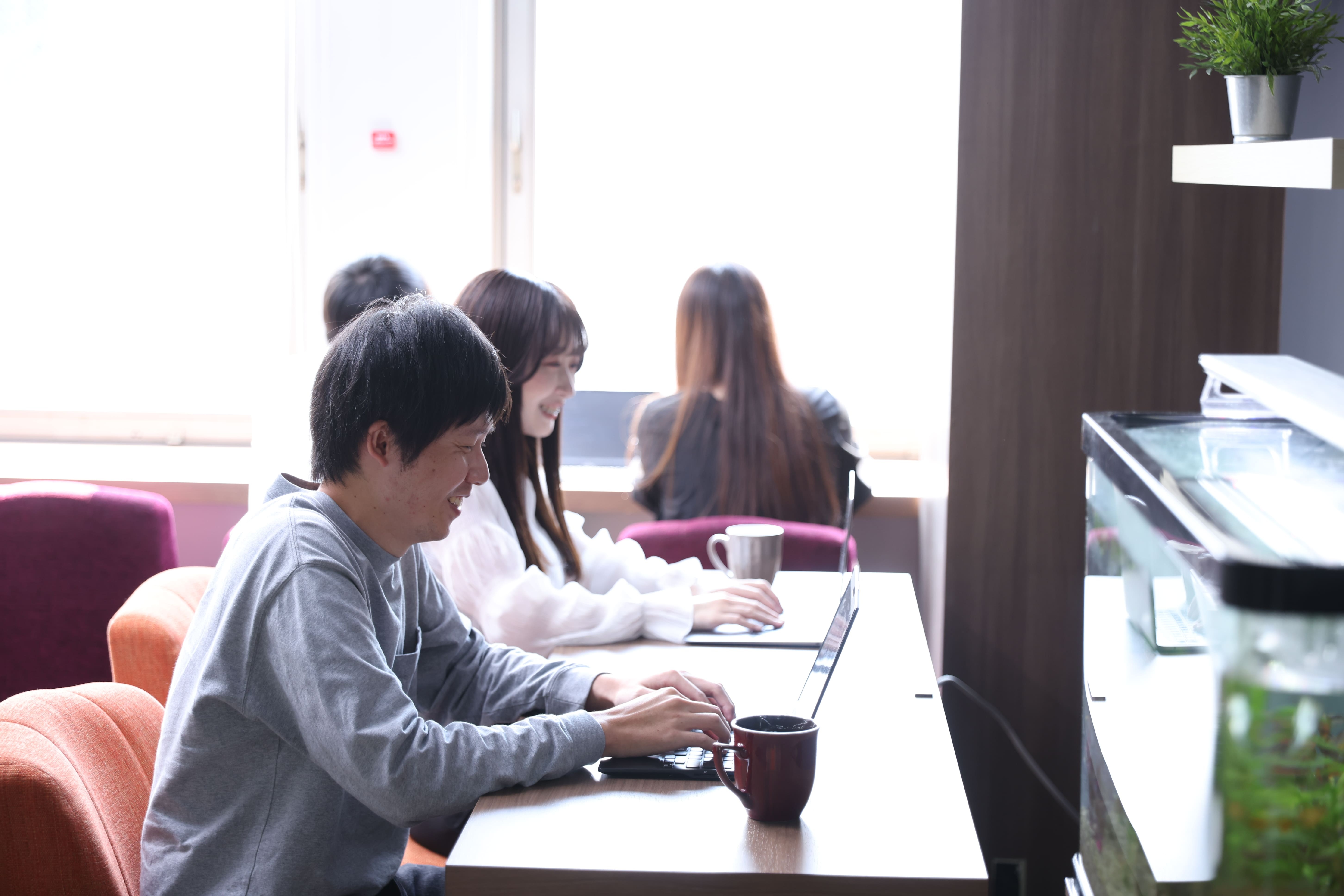 笑顔でパソコン操作をしている男女の写真