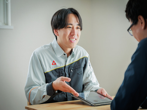 サンリン_男性社員がお客様とタブレットを見ながら話している写真