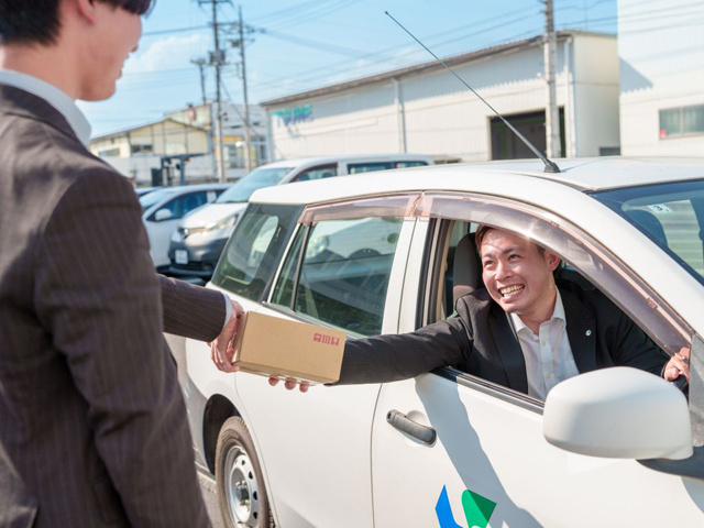 車内から小さい段ボールを渡す男性