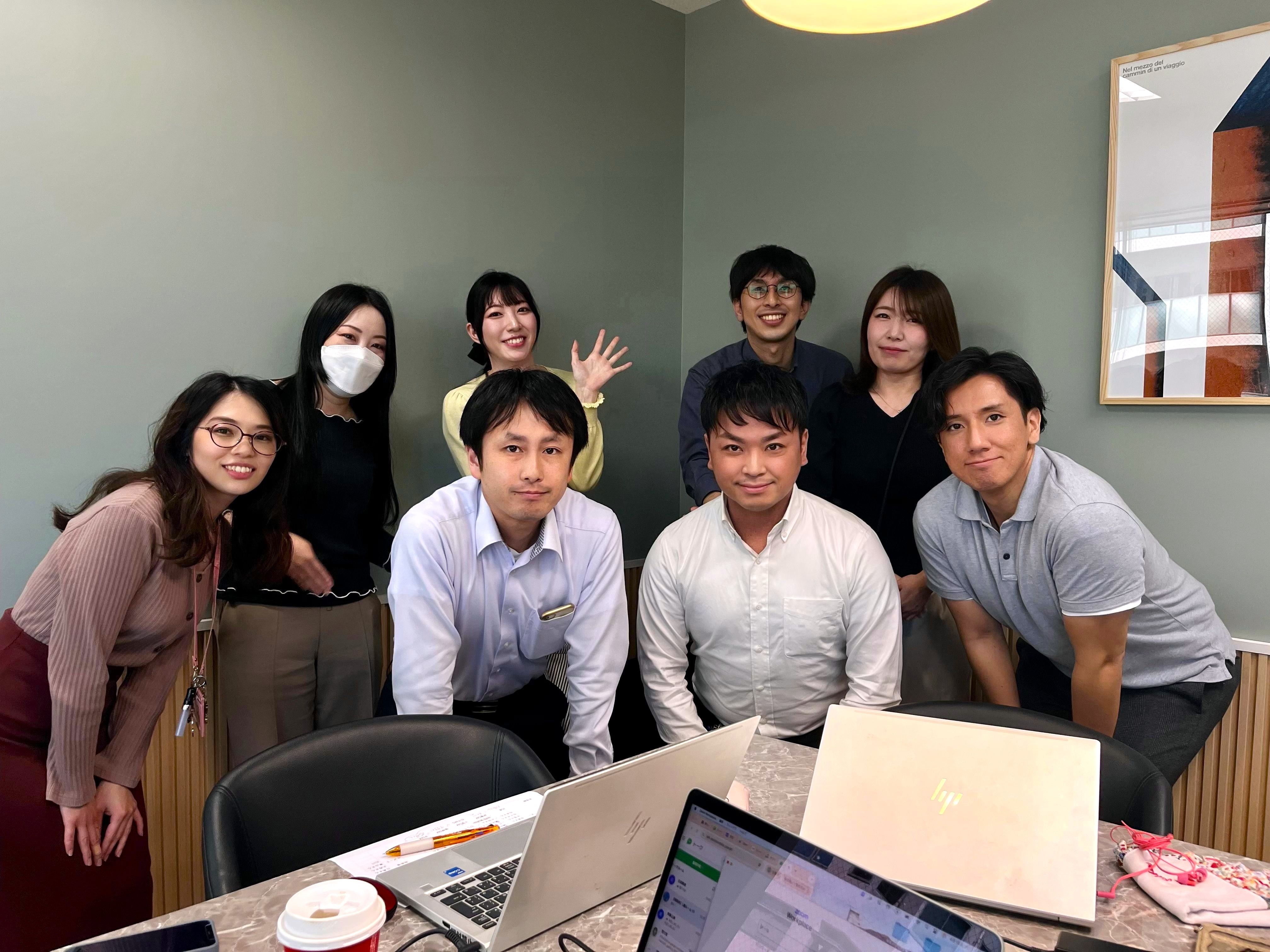 マニフェスト_オフィスで男女8名が写っている集合写真