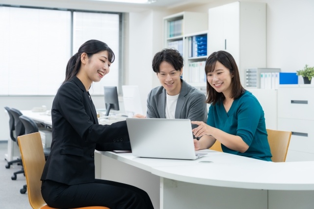 写真素材：若い夫婦と商談をするセールスマン