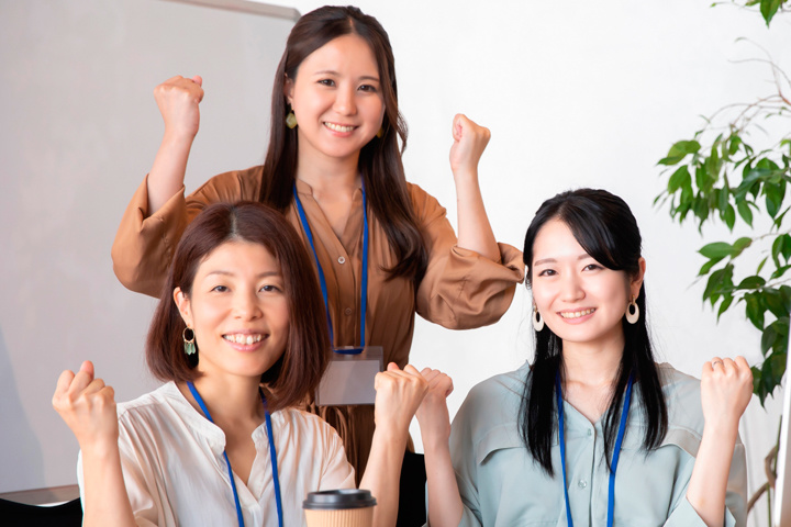 笑顔でガッツポーズをする女性スタッフ