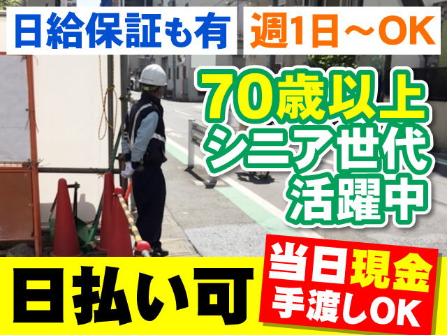 住宅建設現場で交通誘導をしているアウターガードシステムの警備員の写真、日給保証も有、週1日～OK、70歳以上シニア世代活躍中、日払い可・当日現金手渡しOK