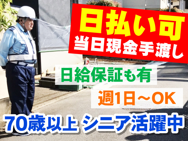 住宅建設現場で交通誘導をしているアウターガードシステムの警備員の写真、日払い可・当日現金手渡し、日給保証も有、週1日～OK、70歳以上シニア活躍中