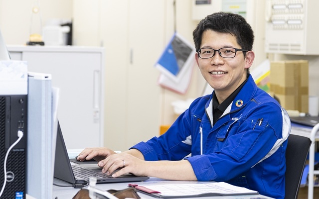 作業着でパソコンを入力する男性