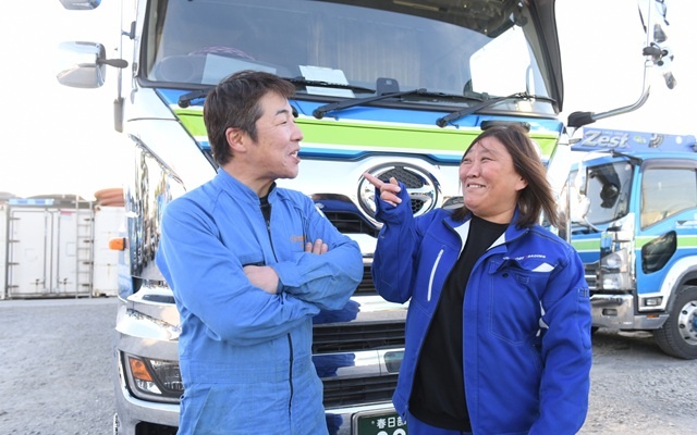 トラックの前で会話する男女