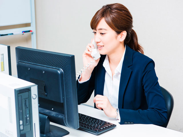 パソコンの前で仕事をする女性の写真