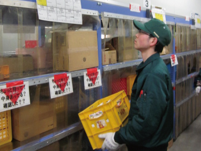 冷蔵商品の陳列作業、棚へ運ぶ男性