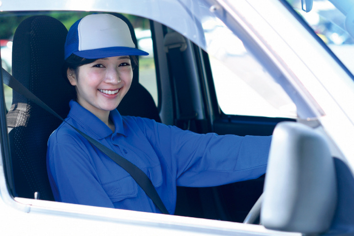 車で配達中の女性スタッフ
