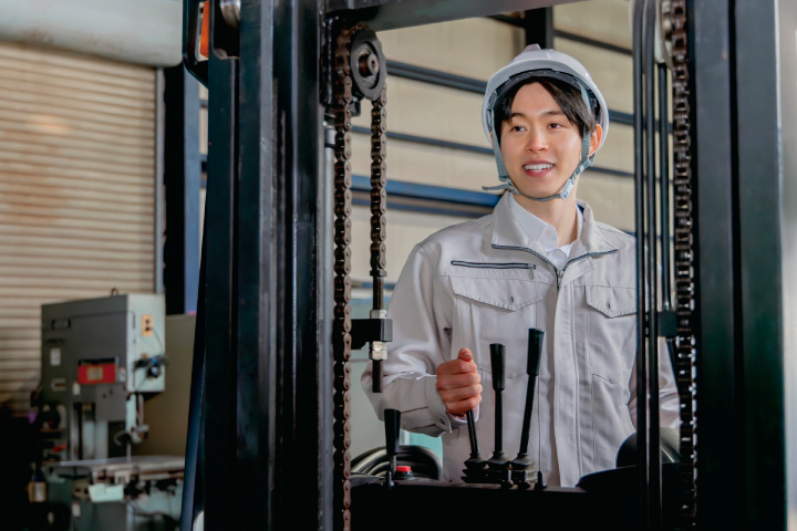 リーチフォークリフトを操作する男性作業員