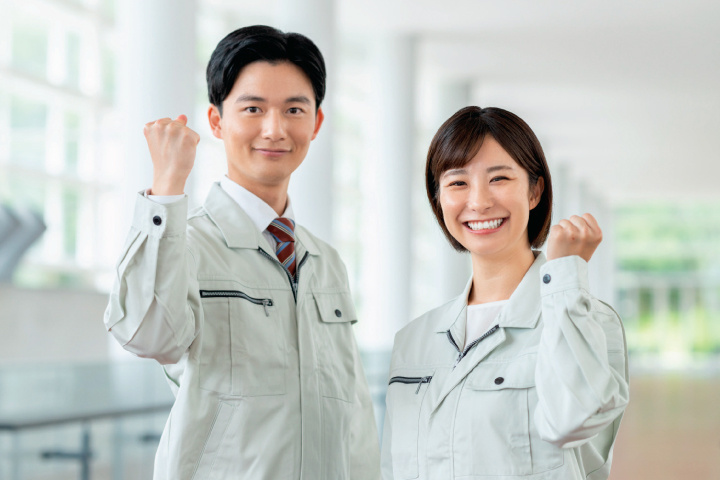 作業服を着てガッツポーズをする男女スタッフ