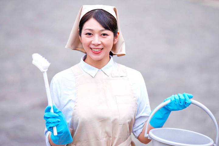 掃除道具を持つ女性清掃スタッフ