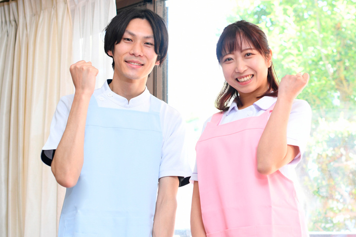 並んでガッツポーズをするエプロンをした男女