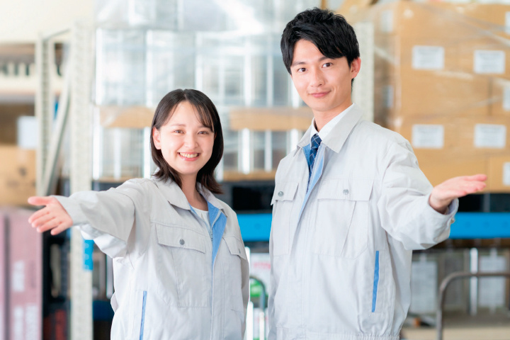 倉庫内の作業服姿の男女の写真