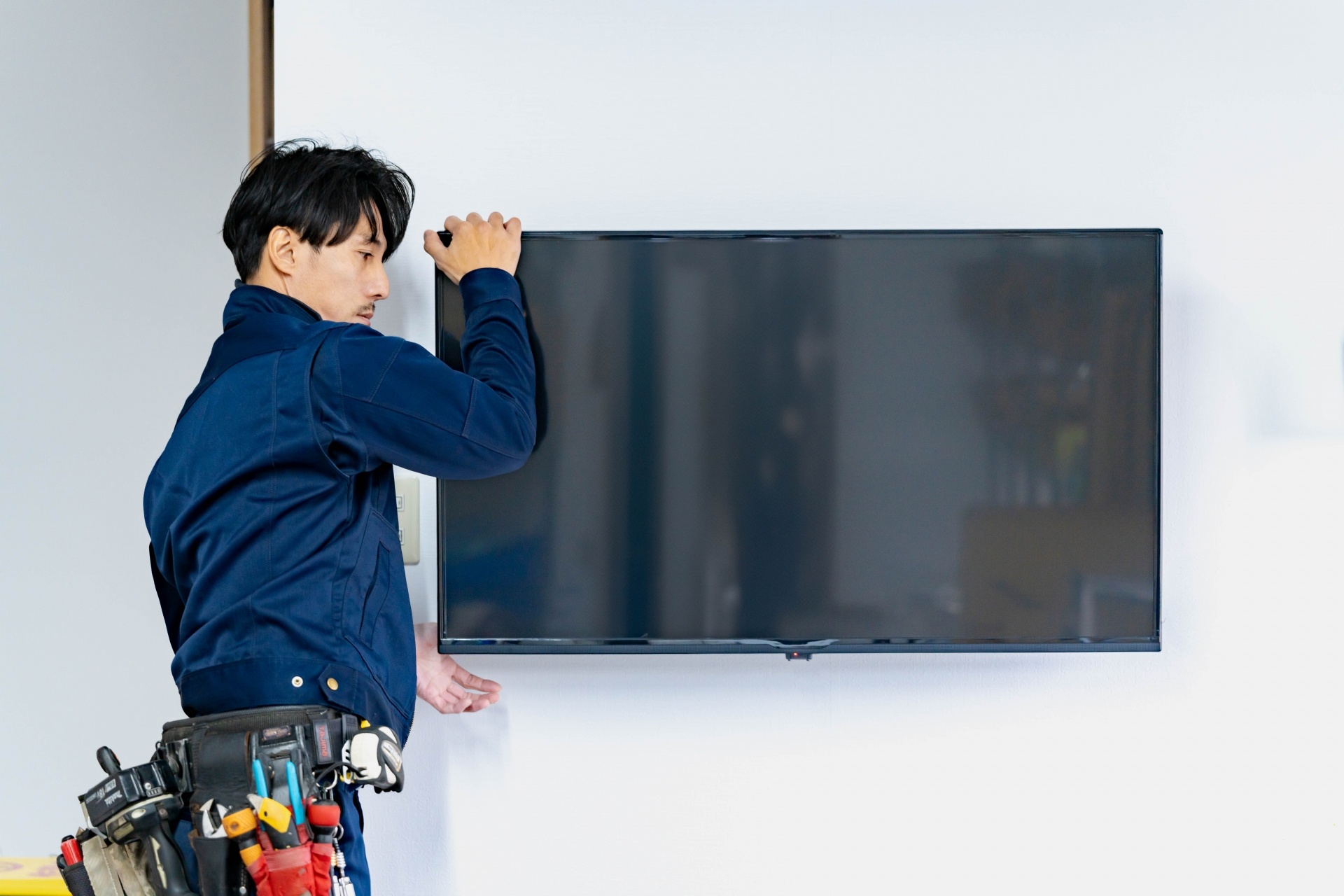テレビなどの家電製品を設置する男性