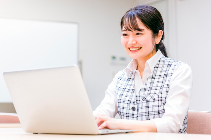パソコン操作をする事務服を着た女性スタッフ