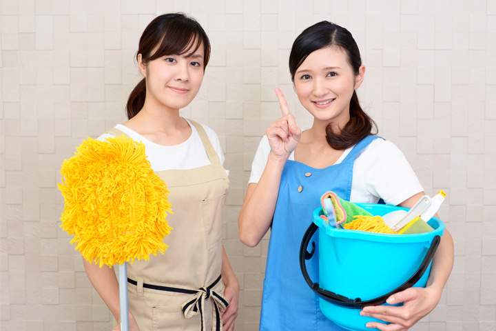 清掃用具を持つ女性スタッフ