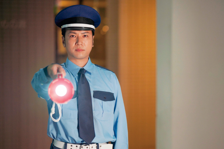 懐中電灯を持つ男性警備員の写真