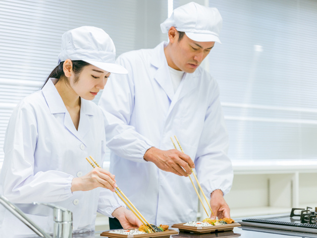 お弁当の盛り付けをする男女