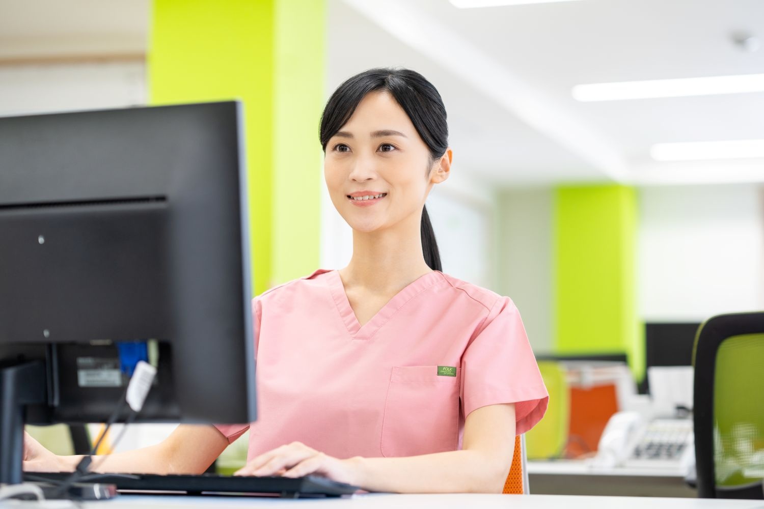 パソコン入力中の看護師(ピンク)
