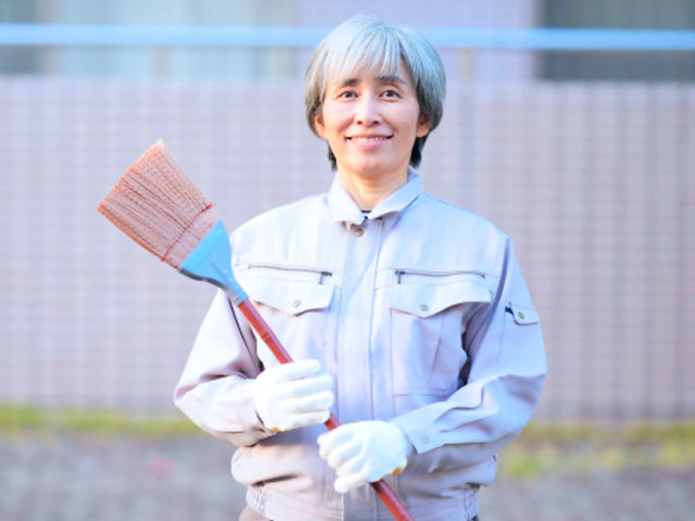 掃除道具を持った年配女性の写真