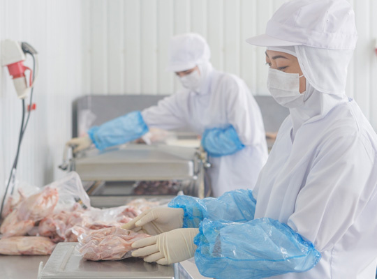 食肉加工の工場で作業するスタッフ