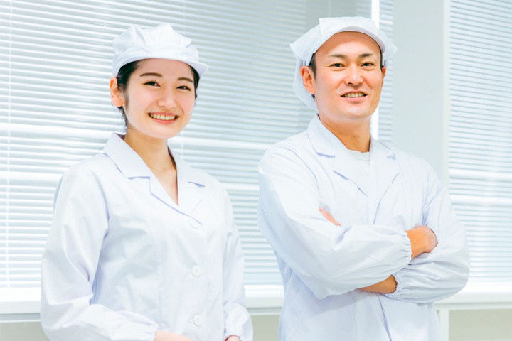 調理服を着て仕事をする男女スタッフ