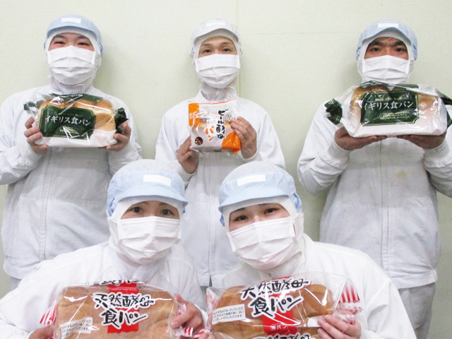 パンを持った工場作業員5人